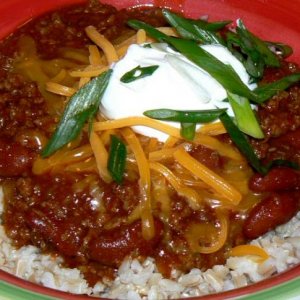Spicy chili  over brown rice topped with cheddar, sour cream and green onions.