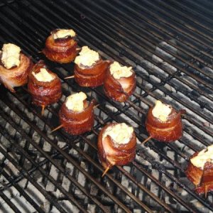 Pork shots on the grill.  Kielbasa wrapped in bacon and topped with seasoned cream cheese.
