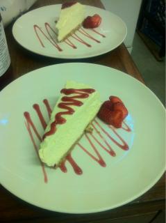 Homemade Vanilla Cheesecake, served with fresh berries and raspberry coulis.