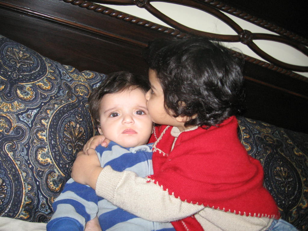 my 2 and a half yrs old daughter kissing his 6 months old bro.
