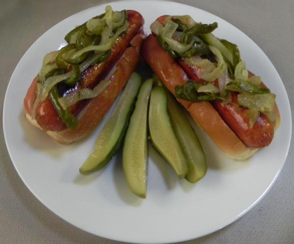 Smoked sausage on a bun with onion and bell peppers