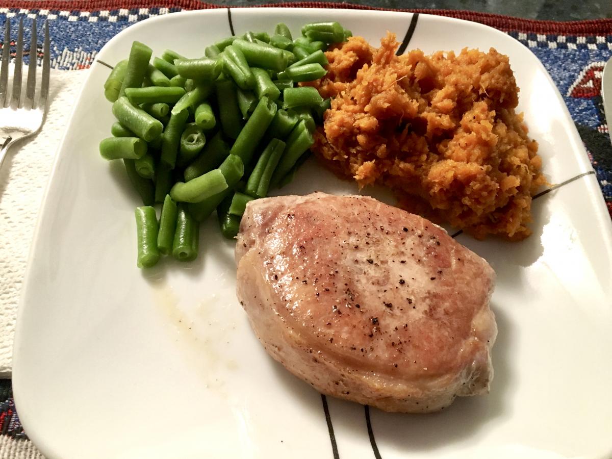 Sous vide pork chop with mashed cinnamon sweet potatoes and green beans.