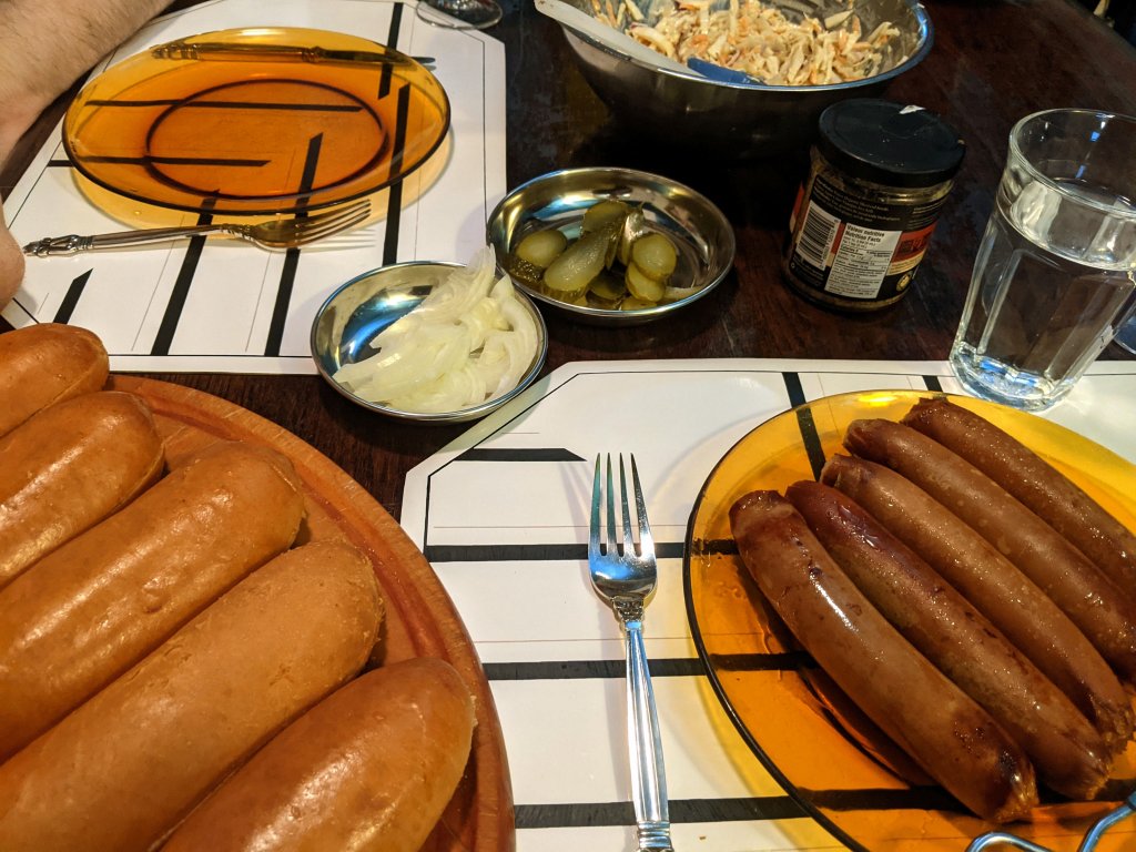 Hot dogs with sliced pickles, onion, and mustard and a side of coleslaw.jpg