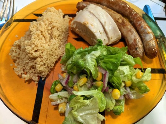 Roast chicken and merguez sausages, whole wheat couscous, and a salad close up.jpg