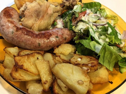 Roasted chicken leg, sausage, and potato slices along with a salad with blue cheese dressing.jpg