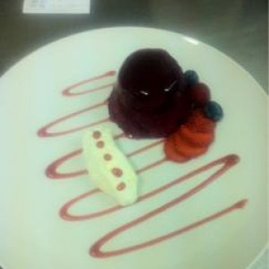 Summer fruit pudding with raspberry coulis and fresh berries, with whipped fresh cream.