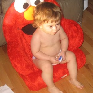 Watching tv in her new Elmo chair. She's almost 15 months old now.