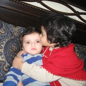 my 2 and a half yrs old daughter kissing his 6 months old bro.