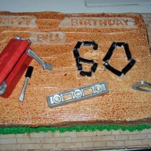 A 60th birthday cake for a hobby carpenter.  The "hardwood floor" detail on the cake board was a thank you for him helping us with our floors.  The to