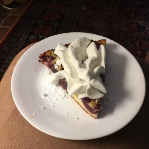 Slice of Cherry Clafoutis with Whipped Cream