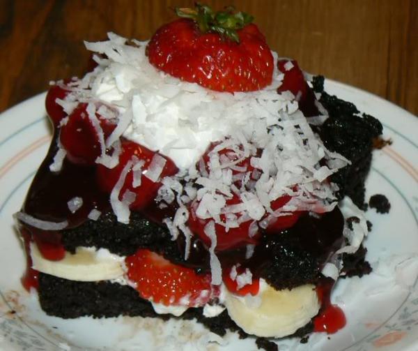 Devils Food Cake with cherry topping, whipped cream, bananas, shredded coconut and strawberries.