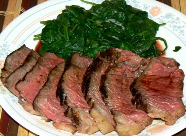 Prime sirloin steak and steamed fresh baby spinach